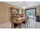 Dining room features a wooden table, chandelier, and backyard pool view at 3414 Rankin Dr, New Port Richey, FL 34655