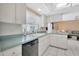 Bright kitchen featuring a black dishwasher, white cabinetry, and neutral countertops at 3414 Rankin Dr, New Port Richey, FL 34655