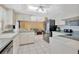 Open kitchen features white cabinets, stainless steel refrigerator and appliances, connecting to the living area at 3414 Rankin Dr, New Port Richey, FL 34655