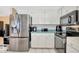 Kitchen featuring stainless steel refrigerator, white cabinetry, and view into adjacent living areas at 3414 Rankin Dr, New Port Richey, FL 34655