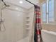 Clean shower featuring neutral tile work, a shower head, and shelves with a window for natural light at 3414 Rankin Dr, New Port Richey, FL 34655