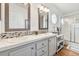 Bright bathroom featuring double vanity with mosaic tile backsplash and framed mirrors at 34506 Rose N Dr, Pinellas Park, FL 33781