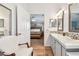 Bright bathroom with double vanity with mosaic backsplash and view into main bedroom at 34506 Rose N Dr, Pinellas Park, FL 33781