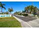 Sunset Palms entrance sign with lush landscaping and American flag at 34506 Rose N Dr, Pinellas Park, FL 33781