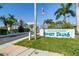 Entrance to Sunset Palms, a resident-owned 55+ active community with lush landscaping and welcoming signage at 34506 Rose N Dr, Pinellas Park, FL 33781