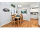 Cozy dining area featuring wood floors, a wooden table set, natural light and wall art at 34506 Rose N Dr, Pinellas Park, FL 33781