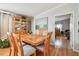 Bright dining room with a wooden table set for six, a display cabinet, and decorative artwork at 34506 Rose N Dr, Pinellas Park, FL 33781