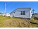 Exterior of home with siding, a small round window and lawn at 34506 Rose N Dr, Pinellas Park, FL 33781