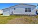 Exterior view of the home showing vinyl siding and a small, decorative round window at 34506 Rose N Dr, Pinellas Park, FL 33781