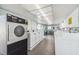 Bright laundry room featuring rows of well-maintained, energy-efficient washing and drying machines at 34506 Rose N Dr, Pinellas Park, FL 33781