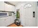 Well-organized pantry with white cabinets and door with built-in coat rack at 34506 Rose N Dr, Pinellas Park, FL 33781
