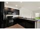 Well-equipped kitchen featuring dark cabinetry, granite countertops, and tile flooring at 3503 Diamond Leaf Ct, Valrico, FL 33594