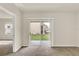 Living room features neutral walls, carpet, and sliding glass door to backyard, creating a bright space at 3503 Diamond Leaf Ct, Valrico, FL 33594