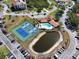 Aerial view showing tennis courts and pool amenities with meticulous landscaping throughout at 433 Mariner Dr # 433, Tarpon Springs, FL 34689