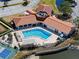 Aerial view of stunning pool and patio with tennis courts, lush landscaping and mature trees at 433 Mariner Dr # 433, Tarpon Springs, FL 34689