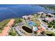 Aerial view of condo community with pool, tennis courts, mature landscaping, and waterfront access at 433 Mariner Dr # 433, Tarpon Springs, FL 34689