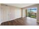 Bright bedroom with hardwood floors, closet, and sliding glass doors leading to a balcony at 433 Mariner Dr # 433, Tarpon Springs, FL 34689