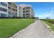 Beautiful waterfront condo building with manicured lawn and walkway leading to the ocean at 433 Mariner Dr # 433, Tarpon Springs, FL 34689
