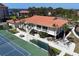 Aerial view of tennis courts, mature palm trees and community clubhouse at 433 Mariner Dr # 433, Tarpon Springs, FL 34689
