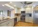 Well-lit kitchen features stainless appliances, granite countertops, and wood-look flooring at 433 Mariner Dr # 433, Tarpon Springs, FL 34689