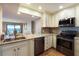 Bright kitchen featuring stainless steel appliances, tile backsplash, and a view into the living space and balcony at 433 Mariner Dr # 433, Tarpon Springs, FL 34689