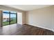 Bright room with hardwood floors and a large sliding glass door leading to balcony at 433 Mariner Dr # 433, Tarpon Springs, FL 34689