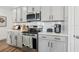 Close-up of the kitchen showing gray cabinets, quartz counters, stainless appliances and modern fixtures at 4587 Georgia Ave, North Port, FL 34288