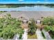 Aerial view of a townhome with a large lake view, brown roof, and driveway surrounded by green trees at 4862 Pond Ridge Dr, Riverview, FL 33578