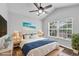This bedroom boasts a stylish bed, a ceiling fan, and a large window providing lots of natural light at 4862 Pond Ridge Dr, Riverview, FL 33578