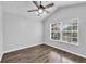 A bright bedroom features wood floors, a ceiling fan, and a large window for natural light at 4862 Pond Ridge Dr, Riverview, FL 33578