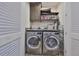 Well-organized laundry room with modern washer and dryer, storage cabinet, and shelving at 4910 W Mcelroy Ave # 6, Tampa, FL 33611