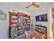 Cozy living room with a comfy chair, large bookshelf, ceiling fan, and a mounted television at 4910 W Mcelroy Ave # 6, Tampa, FL 33611