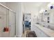 Bright bathroom featuring a shower, double sink vanity, and open doorway to the bedroom at 5646 Cheyenne St, Zephyrhills, FL 33542