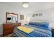 Bright bedroom features a colorful bedspread, ceiling fan, and coordinated decor, creating a cozy and inviting space at 5646 Cheyenne St, Zephyrhills, FL 33542