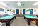 An spacious billiard room with multiple pool tables, overhead lighting, and comfortable ambiance at 5646 Cheyenne St, Zephyrhills, FL 33542
