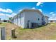 Exterior angle featuring vinyl siding, windows, and an AC unit sitting on a well maintained lawn at 5646 Cheyenne St, Zephyrhills, FL 33542