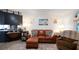 The living room features a comfortable leather sofa, area rug, and adjacent eat-in kitchen at 5646 Cheyenne St, Zephyrhills, FL 33542