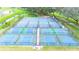 Aerial view of fenced tennis and pickleball courts with blue and green surfaces, perfect for outdoor recreation at 5646 Cheyenne St, Zephyrhills, FL 33542