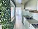 Galley style kitchen with decorative wallpaper, white appliances, and tile flooring at 5660 80Th N St # C101, St Petersburg, FL 33709