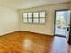 Bright living room with shuttered window, wood-look flooring, and a front door view at 5660 80Th N St # C101, St Petersburg, FL 33709
