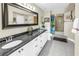 Bathroom featuring double sinks, a dark granite countertop, large framed mirror and a shower with a curtain at 6011 Bahia Del Mar Blvd # 158, St Petersburg, FL 33715