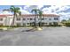 Exterior view of a condominium building with tropical landscaping, parking, and tile roofing at 6011 Bahia Del Mar Blvd # 158, St Petersburg, FL 33715