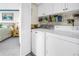 Modern laundry room with white appliances and storage, adjacent to the Primary bedroom at 6011 Bahia Del Mar Blvd # 158, St Petersburg, FL 33715