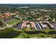 Aerial view of a condo complex surrounded by mature trees, with parking, a pool, and green space at 6150 Gulfport S Blvd # 306, Gulfport, FL 33707