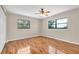 Bedroom with hardwood floors, a ceiling fan, and windows with green outdoor views at 6150 Gulfport S Blvd # 306, Gulfport, FL 33707