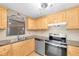 Kitchen with wood cabinets, stainless steel appliances, and granite countertops at 6150 Gulfport S Blvd # 306, Gulfport, FL 33707