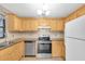 Kitchen with wood cabinets, stainless steel appliances, and granite countertops at 6150 Gulfport S Blvd # 306, Gulfport, FL 33707