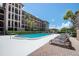 Large community pool with multiple lounge chairs and tall palm trees at 6150 Gulfport S Blvd # 306, Gulfport, FL 33707
