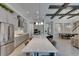 Bright kitchen with gray cabinetry, stainless steel appliances, an island with seating, and open access to the living areas at 6253 Hidden Branch Dr, Apollo Beach, FL 33572