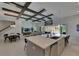 Open-concept kitchen with an island, gray cabinets, stainless steel appliances, and wood beam ceiling, perfect for entertaining at 6253 Hidden Branch Dr, Apollo Beach, FL 33572